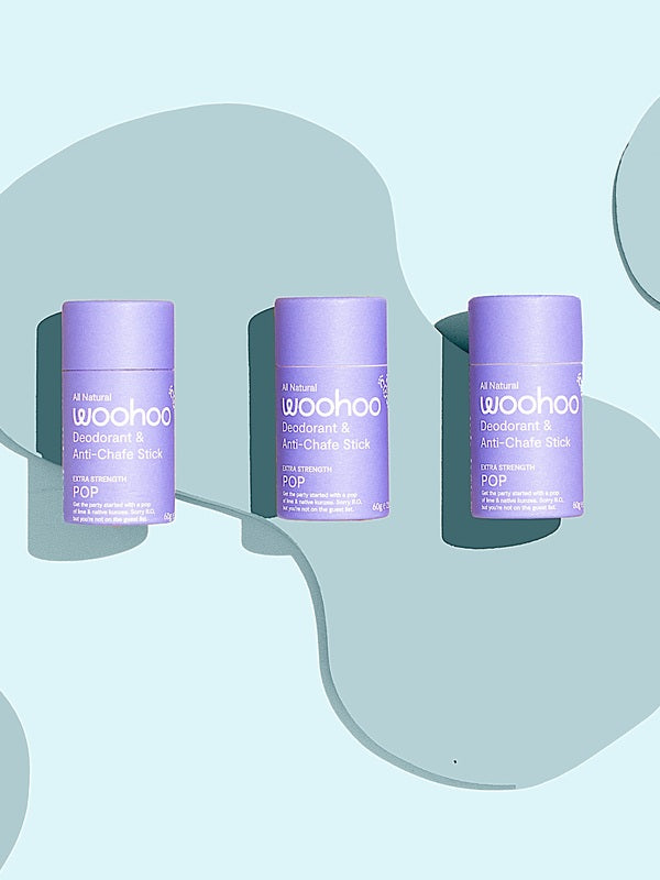 Three WooHoo Pop natural deodorant sticks styled on a graphic background