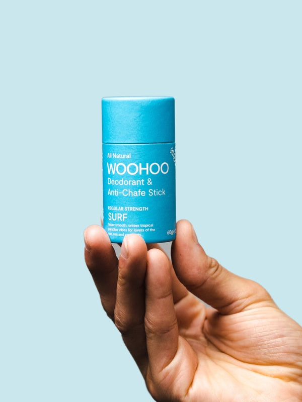 WooHoo Surf natural deodorant stick held in a hand