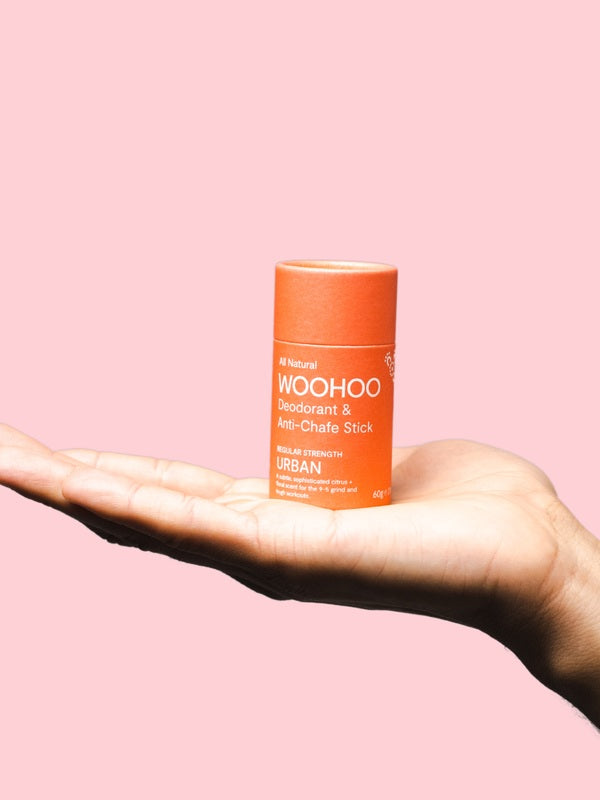 WooHoo Urban natural deodorant stick balanced on an open hand
