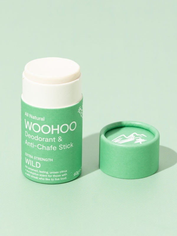 Open WooHoo Wild deodorant stick styled on a green background