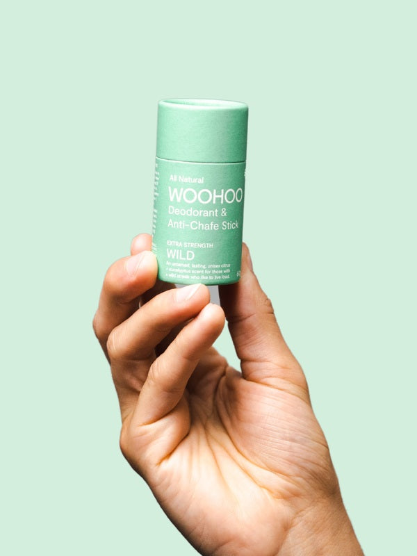 WooHoo Wild natural deodorant stick held in a hand
