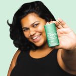 Woman holding WooHoo Wild natural deodorant stick toward the camera