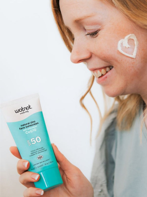 Woman applying Wotnot Natural Zinc Face Sunscreen SPF50 with CoQ10 to her cheek