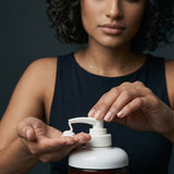 Woman dispensing Yarok Feed Your Curls Defining Crème into her palm