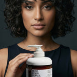 Woman with curly hair holding Yarok Feed Your Curls Defining Crème