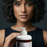 Woman with curly hair holding Yarok Feed Your Curls Defining Crème