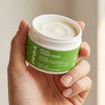Hand holding an open jar of Yarok Feed Your Do Styling Pomade