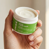Hand holding an open jar of Yarok Feed Your Do Styling Pomade