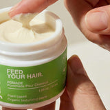 Finger scooping Yarok Feed Your Do Styling Pomade from the jar