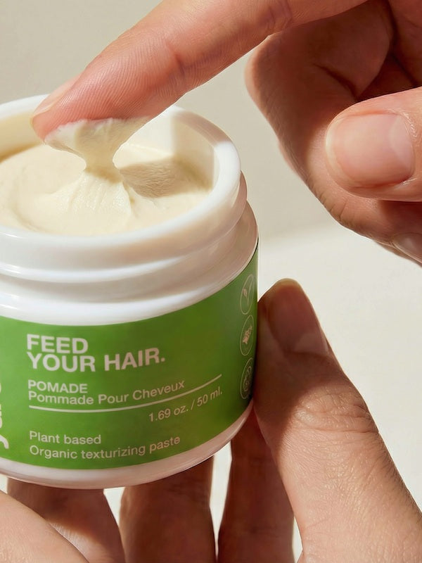 Finger scooping Yarok Feed Your Do Styling Pomade from the jar
