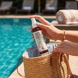 Hand packing Yarok Feed Your Ends Leave-In Conditioner into a poolside bag