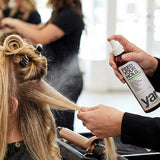Stylist applying Yarok Feed Your Hold Hairspray in a salon