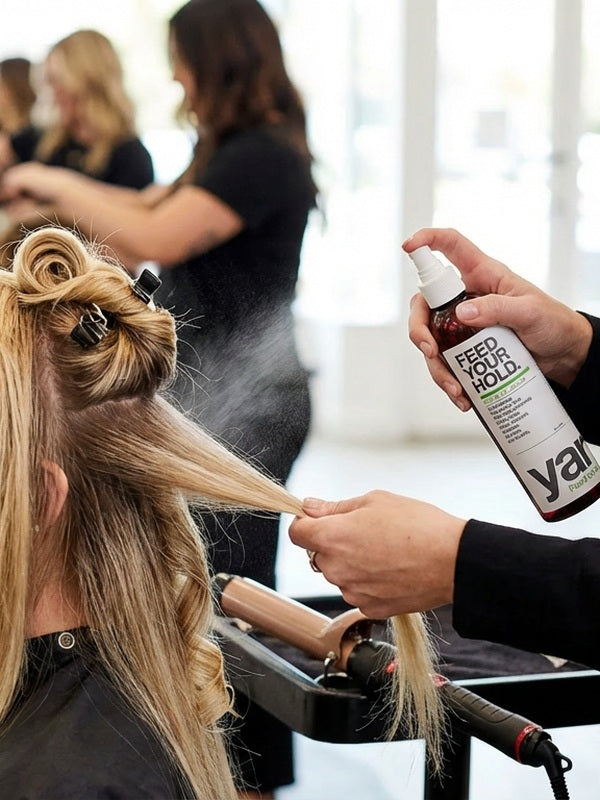 Stylist applying Yarok Feed Your Hold Hairspray in a salon