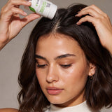 Woman applying Yarok Feed Your Style Dry Shampoo to her roots