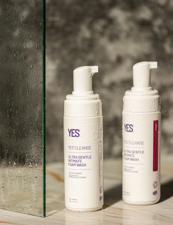 YES Cleanse Rose and Fragrance-Free Intimate Wash bottles in a shower