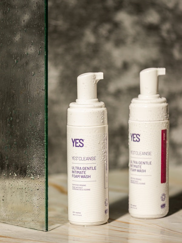 YES Cleanse Rose and Fragrance-Free Intimate Wash bottles in a shower
