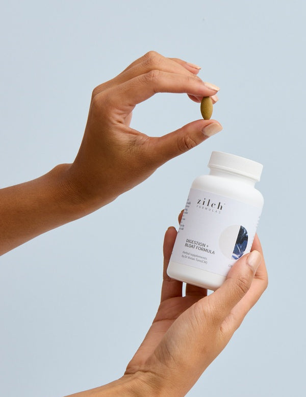 Hands holding Zilch Digestion + Bloat Formula and a tablet – Zilch Digestion + Bloat Formula 120 Tablets