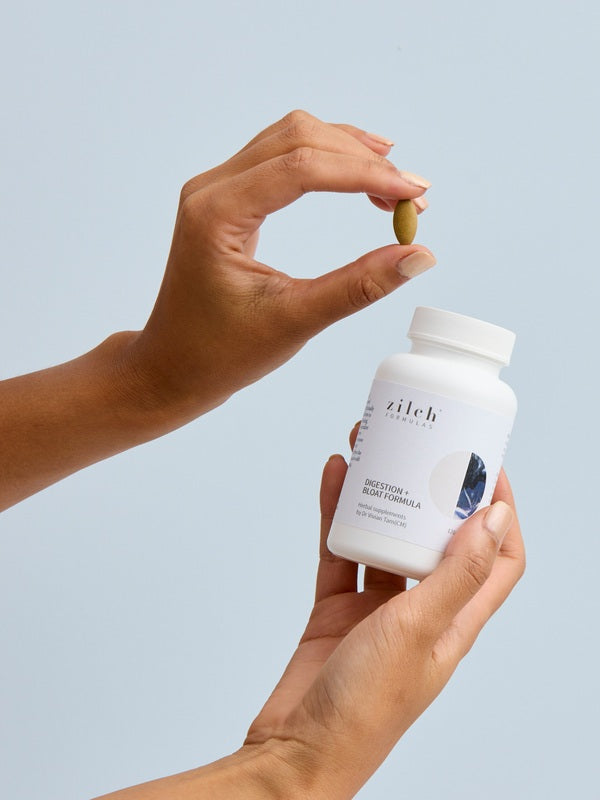 Hands holding Zilch Digestion + Bloat Formula and a tablet – Zilch Digestion + Bloat Formula 120 Tablets